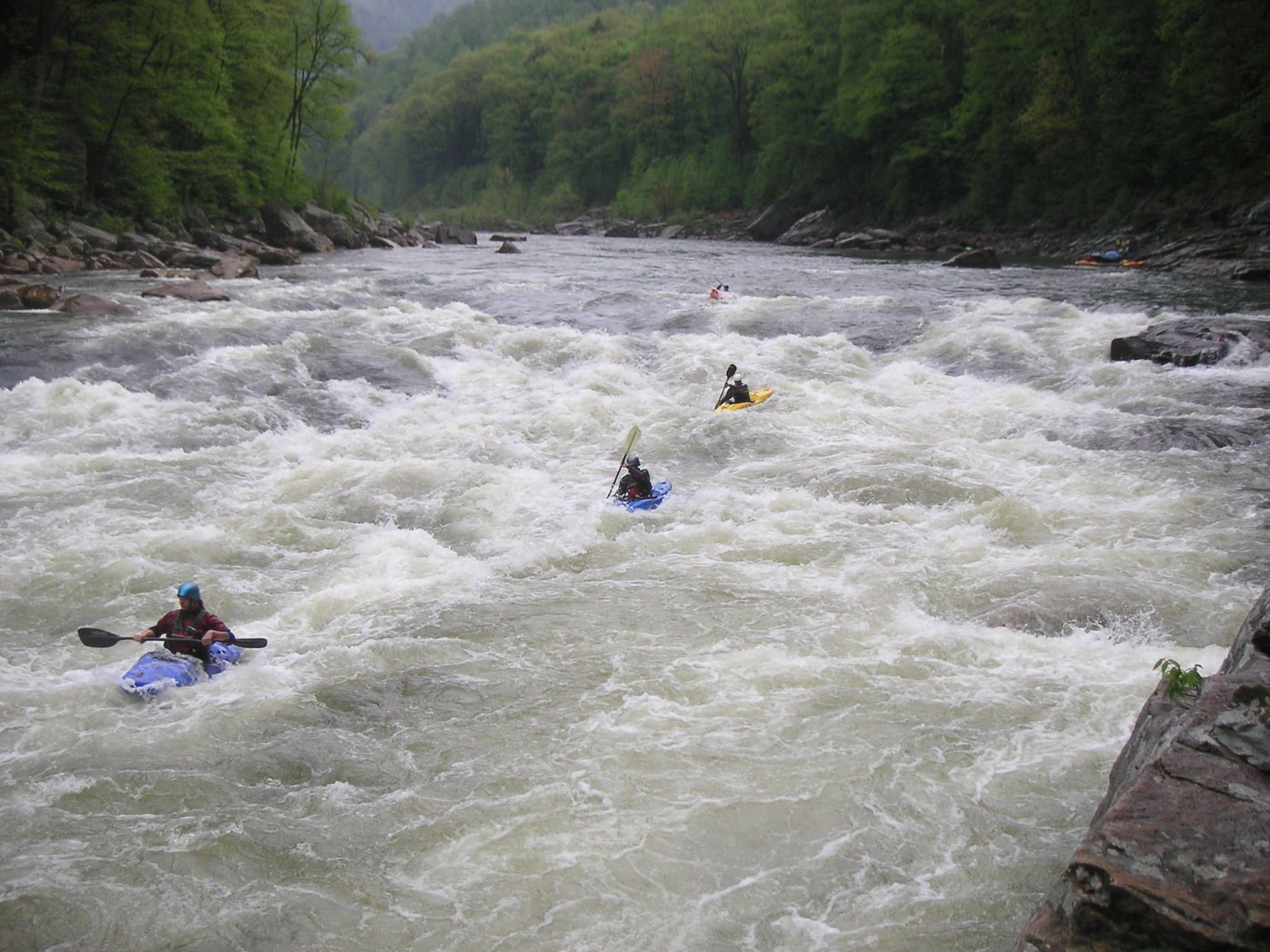 A person battling rapids in a kayak